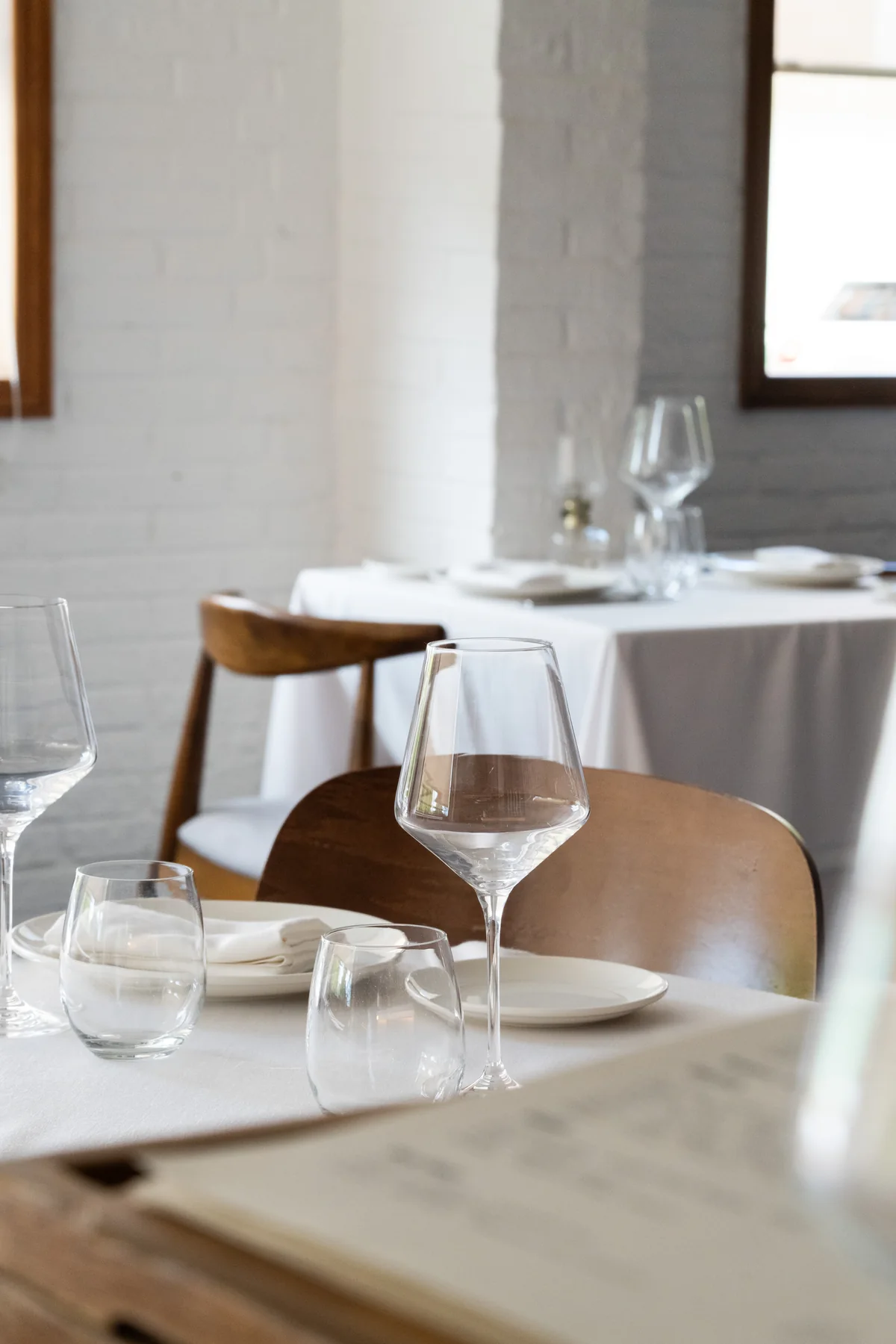 A table by the window, against a white brick wall